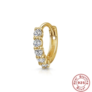 Macro shot of gold S925 sterling silver hoop earring with five inlaid white zircons