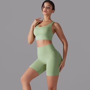 Dettaglio degli shorts da yoga a vita alta e reggiseno sportivo in tessuto verde salvia