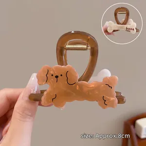 Detail view of cartoon poodle hair claw clip with a bone design and a spring mechanism