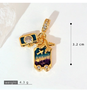 Detail of gold travel charms with airplane, camera and purple gradient suitcase
