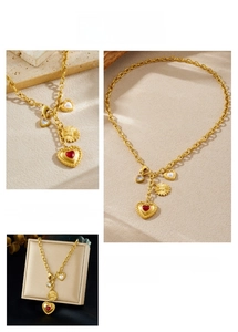 Detail of vintage gold plated chain necklace with red heart and sunflower pendants