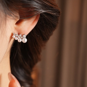 Close-up of elegant 18k gold plated earrings with gradient pearls and sparkling zircons