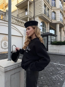 Street style black oversized cotton sweatshirt with heart-shaped bag on a city street