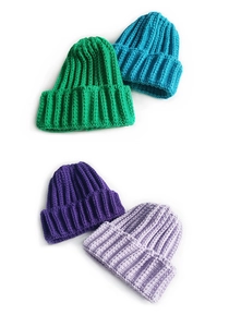 Detailed view of ribbed knit beanies in green, lake blue, and purple tones