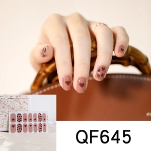 Close-up of pink heart pattern nail art stickers shown with elegant lifestyle accessories