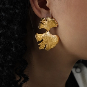 French style 18K gold plated titanium ginkgo leaf earrings shown on model profile