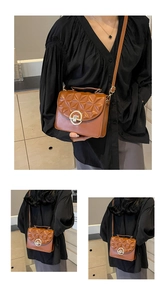 Detail of a brown quilted leather crossbody bag with a round gold buckle on a model
