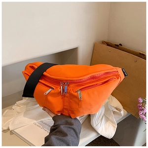 Detailed view of vibrant orange nylon crossbody bag with multi-layer zipper and wide strap