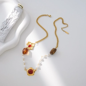 Dettaglio della collana vintage in resina con ciondolo floreale dorato e perle