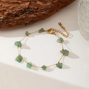 Detailed close-up of golden stainless steel necklace featuring green natural stone beads