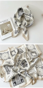 Detailed view of square silk scarf with paisley patterns and champagne gold borders