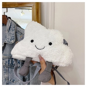 Detailed close-up of a white plush cloud crossbody bag with smiley face and grey knit legs