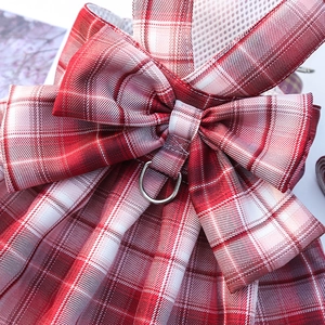 Detail of red plaid pet harness with decorative bow and durable metal D-ring buckle