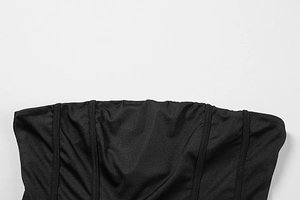 Detailed close-up of structural boning and stitching on a black off-shoulder corset dress