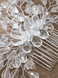 Macro shot of silver bridal hair comb with intricate crystal beads and pearl flower details