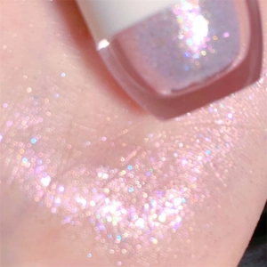 Macro di ombretto liquido rosa perlato con glitter fini sulla superficie della pelle