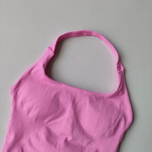 Detailed close-up of pink halter yoga tank top showing ribbed knit fabric texture
