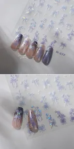 Close-up of 5D embossed bow and flower nail art stickers with holographic purple finish