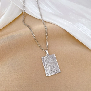Macro view of silver titanium steel square pendant with engraved dragon pattern