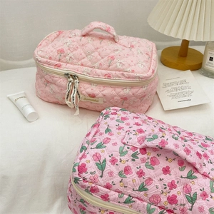 Pink quilted cotton toiletry bags with floral patterns and sturdy zip closures
