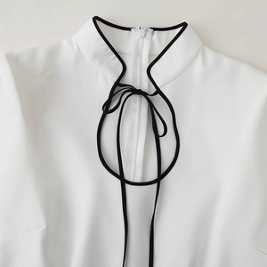 Elegant long sleeve dress with stand collar and black tie detailing in white fabric