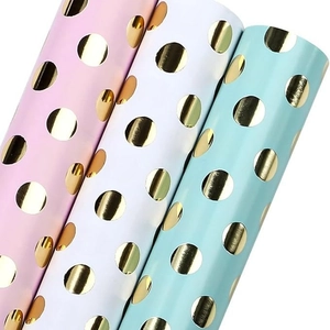 Colorful dot patterned gift wrapping paper rolls with metallic gold foil stamping finish