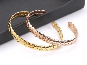 Detailed view of gold and rose gold stainless steel cuff bangles with wheat texture