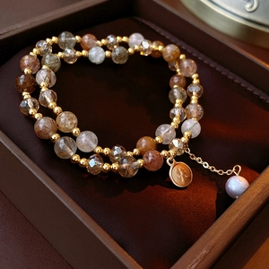 Detailed macro view of multi-layer beaded bracelet with natural crystals and pearl in box