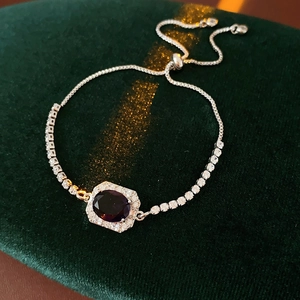 Detail of adjustable silver bracelet with purple oval gemstone and zircon halo inlay