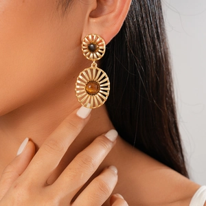 Detailed view of vintage gold hollow earrings with tiger eye stone on model