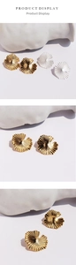 Detailed view of matte silver and gold ginkgo leaf earrings with radial leaf textures