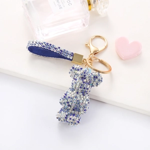 Detailed close-up of a luxury blue rhinestone bear keychain with gold metal hardware