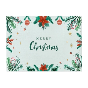Detail of Christmas placemat with green plant print and Merry Christmas text on linen fabric