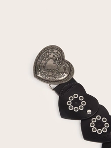 Close-up of vintage heart buckle with floral engravings and black PU leather strap