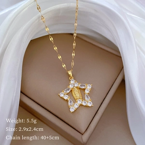 Detail of gold star pendant with zircon inlay and Virgin Mary relief on silk background