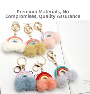 Detail view of colorful rainbow keychains with plush pom poms and gold alloy clasps