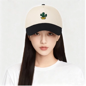 Détail d'une casquette bicolore avec broderie de cactus sur couronne beige et noire
