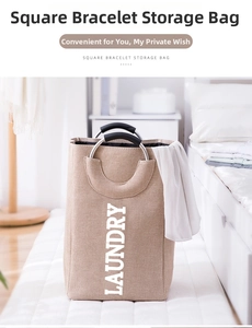 Detail of square linen laundry basket featuring round metal handles with soft foam grips