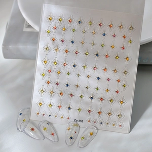 Macro detail of 3D nail stickers featuring hollow stars and colorful rhinestone accents