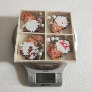 Weight display of four wooden Christmas gnome ornaments in a wooden storage box