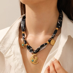 Detail of printed fabric choker necklace with moon owl, star, and turquoise pendants