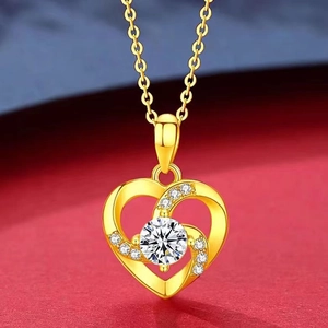 Close-up of golden heart pendant featuring a large center crystal and accent diamonds