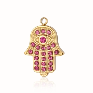 Detailansicht eines vergoldeten Hamsa-Hand-Anhängers mit funkelnden rosa Schmucksteinen