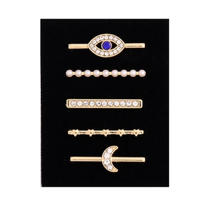 Detail of 5-piece gold alloy charms for watch bands with evil eye, pearls and star shapes