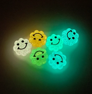 Primo piano di perline sorridenti luminose a forma di fiore che brillano in giallo e blu