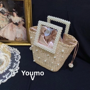 Detail of handmade straw bucket bag with pearl handle and pink satin drawstring lining