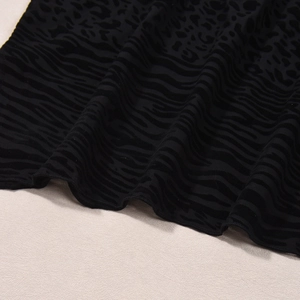 Détail du tissu en mesh noir avec motifs floqués de zèbre et léopard texturés