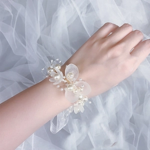 Nahaufnahme der floralen Handgelenk-Corsage mit Perlen und Spitzenband für Blumenmädchen