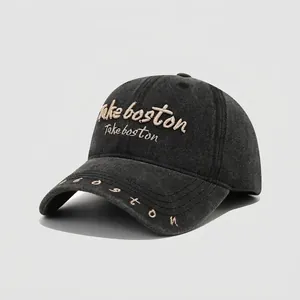 Dettaglio del ricamo dorato Boston su berretto da baseball in cotone grigio bimbo