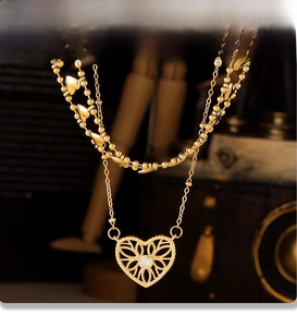 Macro view of double-layer gold necklace with hollow heart pendant and PVD coating